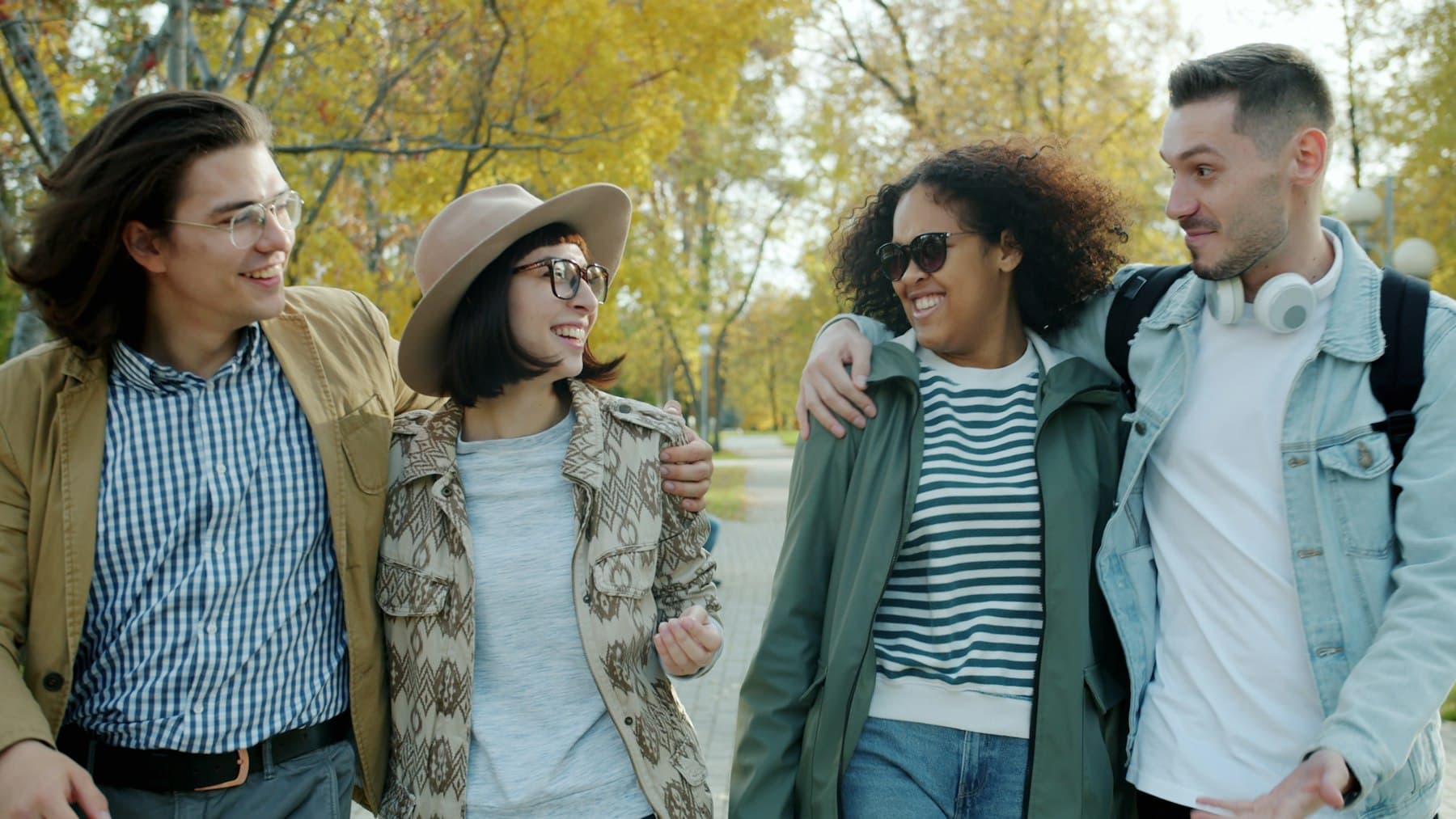 A group of friends walking and laughing together in a park